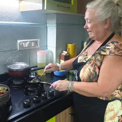 My kitchen is a hands-on space. You won't just be watching, you'll be chopping, stirring, and frying yourself. Here's a guest from my recent Mumbai cooking class getting the hang of tempering spices for a classic Maharashtrian dish.