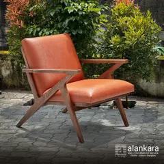 Our 'Cabo' chair, crafted from seasoned European ash wood and upholstered in rich, tan art leather. The angular, Z-shaped frame makes it a modern design statement for any room or covered patio.