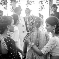 A black and white photo capturing a bride being comforted by her sisters. These emotional, supportive moments between family are the heart of a wedding.