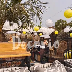 This outdoor baby shower setup shows my work for daytime events. The decor features a cheerful yellow and white theme with paper lanterns and balloon clouds, perfectly complementing the natural greenery of the venue.