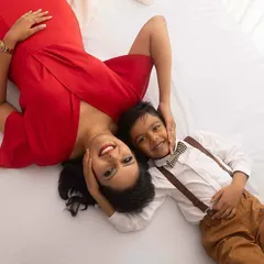 A sweet overhead shot of a mom and her son lying on the bed together. This perspective creates a lovely, intimate portrait that celebrates their special bond before the new baby arrives.