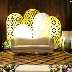 A beautifully designed stage backdrop with illuminated jali-cut arches, creating a perfect setting for the couple.