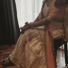 A candid shot from a fitting, showing the details of an ivory and peach sharara set. These moments of collaboration are a huge part of my process.