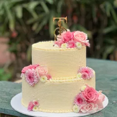 I love bringing your grand celebrations to life. This two-tiered custom cake, adorned with fresh pink roses and chrysanthemums, was designed to be an elegant centerpiece for a very special day.