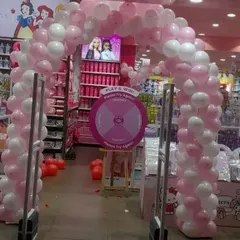 A classic pink and white balloon arch created for a promotional event inside a mall. This type of decoration is perfect for drawing attention to a store entrance or a special activity zone.