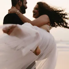The pure joy of being swept off her feet. This candid moment of laughter and movement by the sea is what makes a pre-wedding shoot feel alive and full of energy.