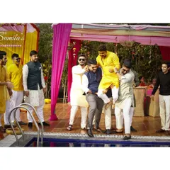 The moment before the splash. The groom's friends carrying him towards the pool is a classic Haldi tradition, full of anticipation and fun.