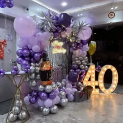 I designed this complete setup for a 40th birthday party. It includes a circular balloon arch, a silver fringe curtain, a custom neon sign, and large marquee numbers for a stylish photo backdrop.