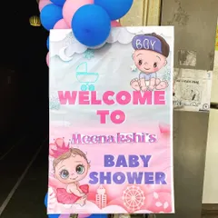 A custom welcome board for Meenakshi's baby shower, with cute "boy or girl" graphics.