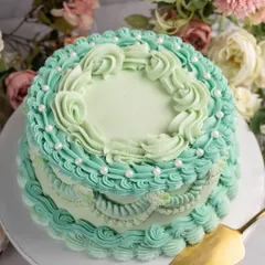 I am obsessed with bringing back classic designs. This cake features intricate, vintage-style Lambeth piping in a beautiful Tiffany blue buttercream over a rich dark chocolate ganache cake. It's elegance you can eat.