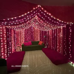 I can transform your entire living room into a festive haven. Here, I've used rich magenta fabric to create a cozy tent-like canopy, with strings of fairy lights creating a magical, starry effect perfect for Diwali parties or home pujas.