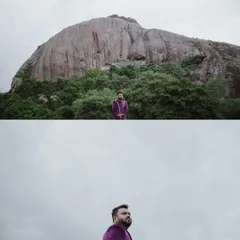 A dramatic wide shot of the groom standing alone against a massive rock formation, creating a powerful and solitary portrait.