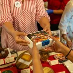 Handing over a box of our Christmas treats at a festive pop-up. Our gift boxes are a popular choice for sharing the holiday spirit with friends, family, and colleagues.