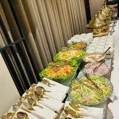 This catering spread for a corporate event features a fresh salad bar alongside hot main courses. We ensure every element, from the cutlery to the serving bowls, is arranged for a clean and professional presentation.