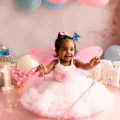 A happy moment from a first birthday session. We added fairy wings and a magic wand to the butterfly theme, letting her personality shine through with a bright, joyful smile.