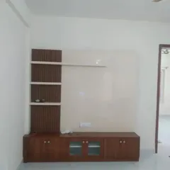 This modern TV unit combines a natural wood finish on the cabinets and shelves with a smooth, off-white painted back panel for a clean and contemporary look.