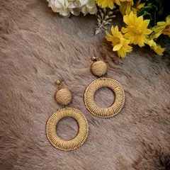 A beautiful flat-lay of the bohemian woven straw dangle earrings, perfect for your next vacation.