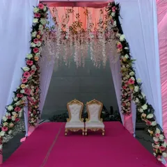 A closer view of the pink and white stage, showing the hanging floral details at the top and the elegant chairs. This design is perfect for a ring ceremony or reception.