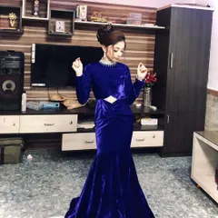 This is a full look at the custom blue velvet gown. It features long sleeves and a subtle neckline detail, designed to be both elegant and comfortable for a long evening of celebration.