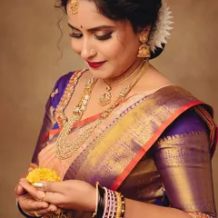 I love capturing the small, gentle moments. This close-up on her hands holding flowers shows the intricate jewelry and the beautiful texture of the saree's fabric.