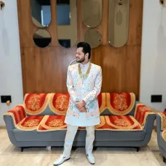 A full-length shot of the floral sherwani. The groom looks stylish and confident in this unique and colorful outfit.
