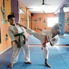 Sparring drills like this teach our young students timing, distance, and control. This student is practicing a controlled kick, an important part of our kids' karate and taekwondo training.
