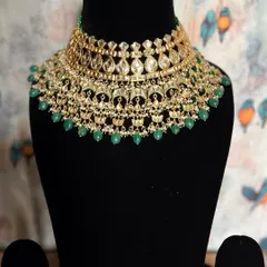 An ode to timeless elegance. This Kundan choker with green pearl drops is a magnificent piece that adds a touch of royalty to your wedding attire.