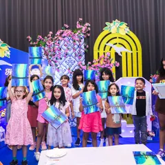 A group of proud young artists showing off the beautiful paintings they created during the guided canvas painting session.