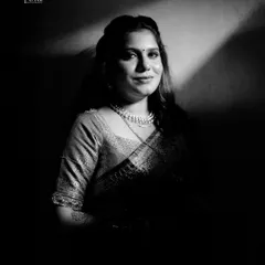 A striking black and white portrait of the bride. Her direct gaze and gentle smile convey a sense of confidence and grace.