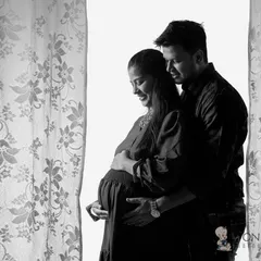 This black and white portrait uses the soft light from a window to create an intimate and timeless feel. It’s a quiet, tender moment between partners, captured in a classic, artistic style.
