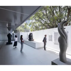 The sculpture court is a semi-open gallery, blurring the line between inside and outside. It allows art to be experienced with natural light and a connection to the surrounding trees, creating a serene, contemplative atmosphere.