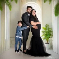 A full family portrait in the studio, with the older brother hugging his parents. It's a wonderful way to capture the family dynamic before the new baby joins.