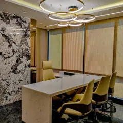 A wider view of an executive cabin at the Sun Group office. The space is designed for both work and meetings, with a clean, solid-surface desk and comfortable seating, all framed by a stunning view.