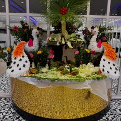 Another example of our intricate vegetable carving, featuring two swans and a palm tree, all set on a beautifully decorated round table.