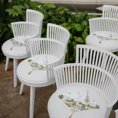 A playful detail from our "Tale as Old as Time" theme. These modern white chairs were customized with a printed fan on the seat, featuring illustrations that told the couple's story.