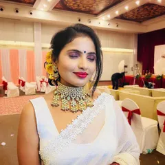 A close-up of the reception makeup, showing the blend of the smokey eyeshadow and the vibrant lip color. The yellow flowers in her hair add a beautiful, traditional touch.