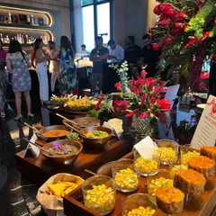 A wide shot of our Mexican food station, featuring a variety of salsas, corn salads, and other delicious toppings for tacos and nachos. The setup is bursting with color and flavor.