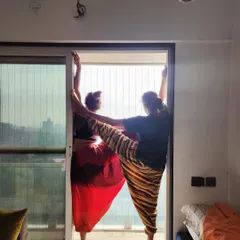 "Aaj kuch toofani karte hain." A playful moment of connection, supporting each other in a standing balance pose.