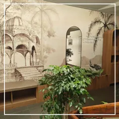 The executed focus wall on the stair landing, where the heritage-inspired wallpaper, integrated seating, and lush greenery come together. The arched mirror cleverly reflects the space, making it feel larger and more dynamic.