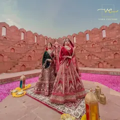 Two brides, one royal vision. Showcasing two of my most exquisite bridal lehengas, one in deep green and the other in classic red, perfect for a grand wedding ceremony.