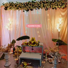 For a Gauri Maa puja, I designed this elegant and serene setup. It includes a beautiful floral arrangement overhead, soft peach drapery with subtle lighting, traditional banana leaves, and floor lamps to create a warm, divine atmosphere.
