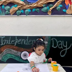 This young learner is engaged in a paper-pasting activity to create the Indian flag. It's a wonderful way to enhance hand-eye coordination and celebrate our country.
