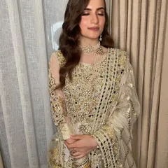 A full look at this stunning outfit. The makeup is kept sophisticated and radiant to complement the heavy gold and mirror work, ensuring the overall look is balanced and chic.