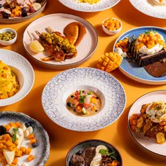 A celebration of mango season at Bastian. This top-down shot captures a wide array of mango-themed dishes, from savory to sweet, showcasing the creativity and breadth of the restaurant's seasonal menu.