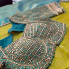 The structured bodice of the teal blouse, featuring vertical lines of beadwork that create a corset-like effect, combining traditional embroidery with modern design.