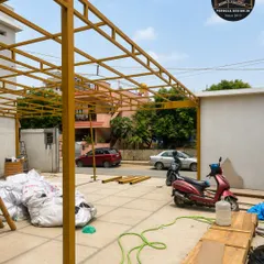 Every great carport starts with a strong foundation. This image shows the precisely fabricated steel framework for a large parking structure, coated with a primer for rust protection. Our process ensures every joint is secure and the entire structure is perfectly level before finishing.