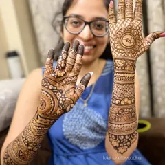 The lovely Siddhi, all smiles with her personalized engagement mehendi featuring her and her fiancé's initials.