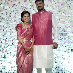 A beautiful couple portrait. The groom's custom pink brocade Nehru jacket was designed to perfectly match the bride's stunning pink Kanjivaram saree, creating a classic and coordinated reception look.