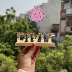 A personalized monogram stand for Divit. The resin letters are filled with colorful flowers and set on a wooden base, making it a perfect decoration for a desk or shelf.