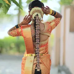 A stunning traditional bridal braid. This hairstyle is decorated with intricate gold-plated accessories and fresh jasmine flowers, creating a rich and timeless look for the bride.